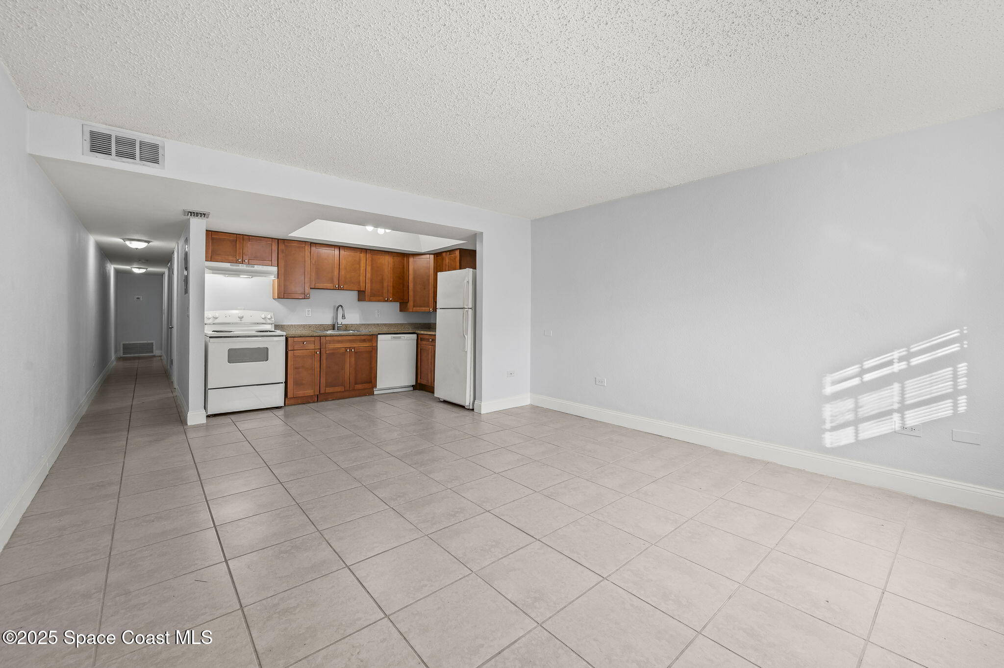 1170 South Patrick Drive, Unit 29 Satellite Beach, FL 32937 - Photo 8 of 18 a view of a livingroom with a dishwasher and a refrigerator