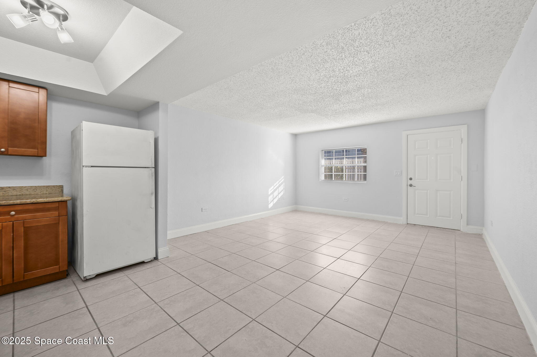 1170 South Patrick Drive, Unit 29 Satellite Beach, FL 32937 - Photo 10 of 18 a view of a refrigerator in kitchen and white cabinets