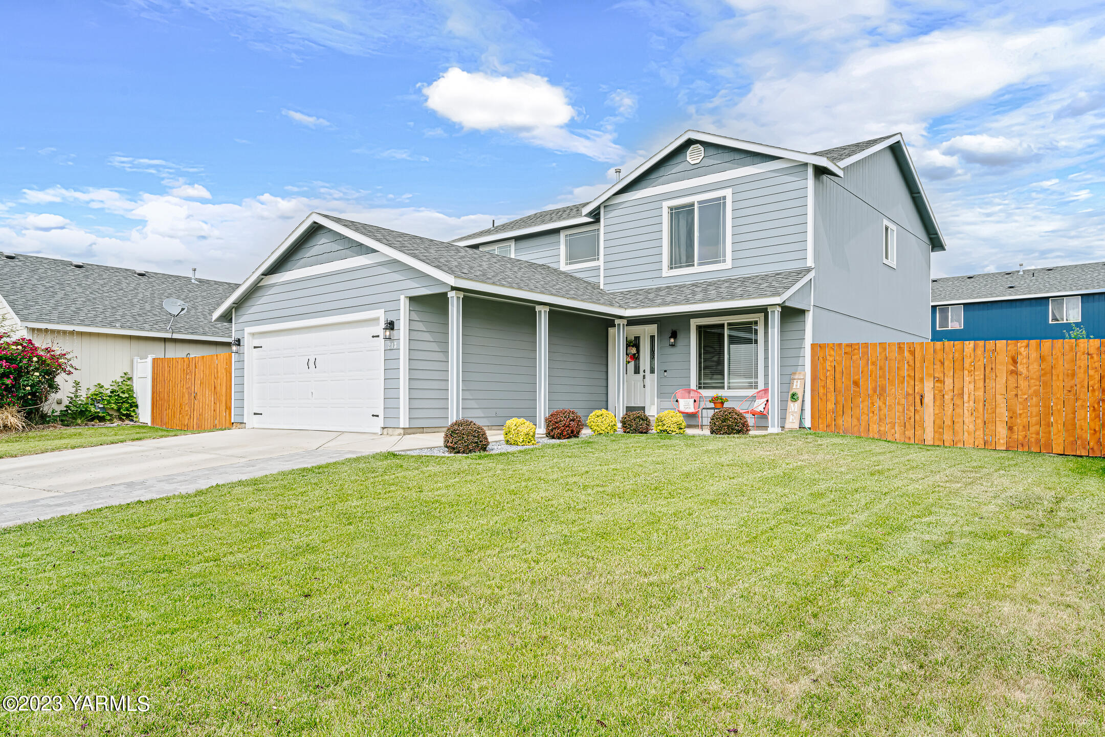 a front view of house with yard and trees in the background