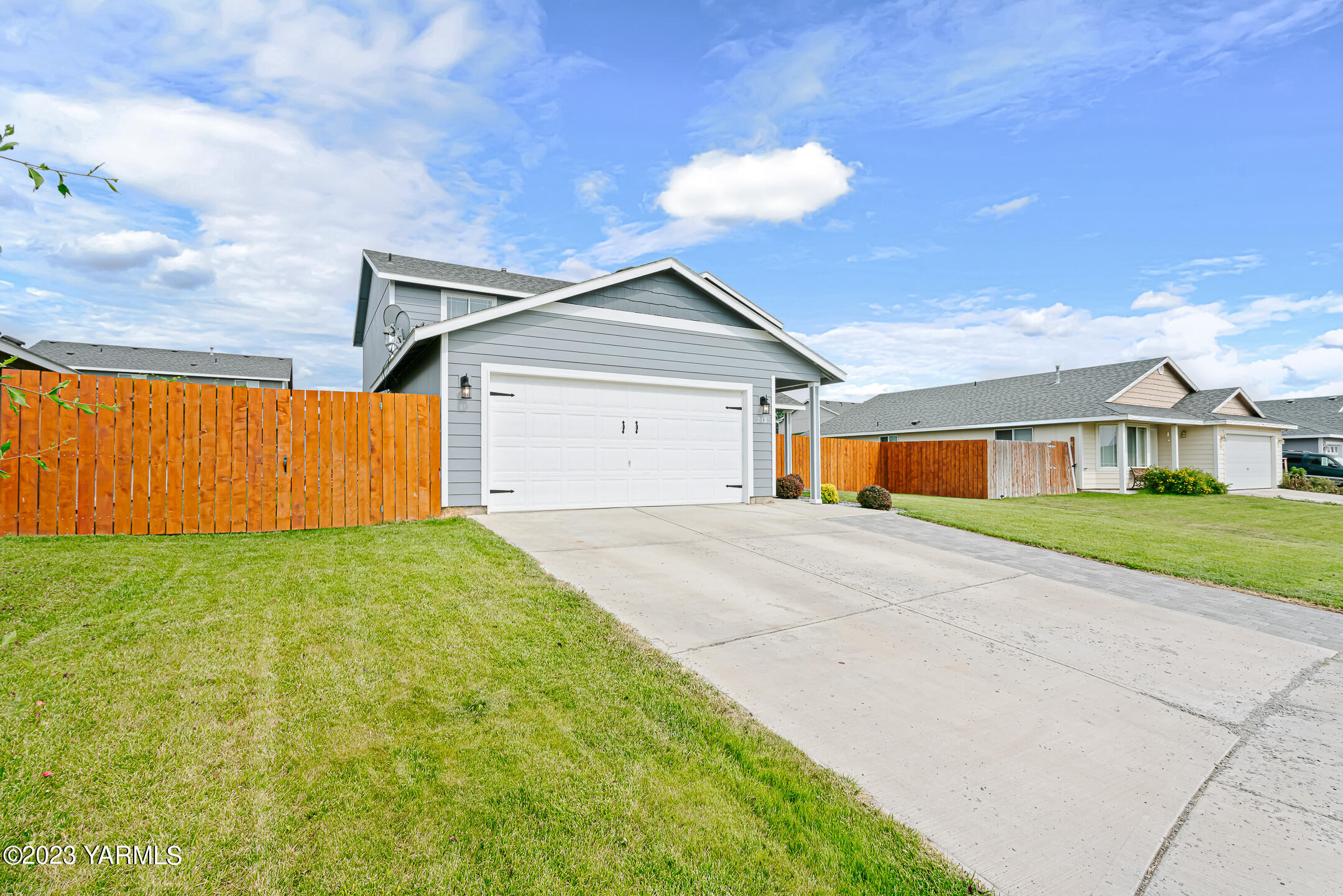 213 Perle Street Moxee, WA 98936 - Photo 3 of 27 a front view of a house with a yard and garage