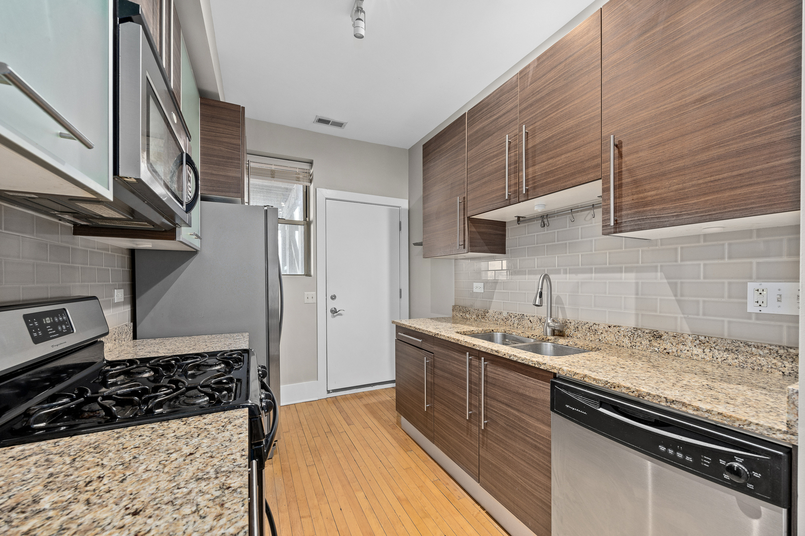 3418 North Wolcott Avenue, Unit 1N Chicago, IL 60657 - Photo 5 of 16 a kitchen with a sink stove and cabinets