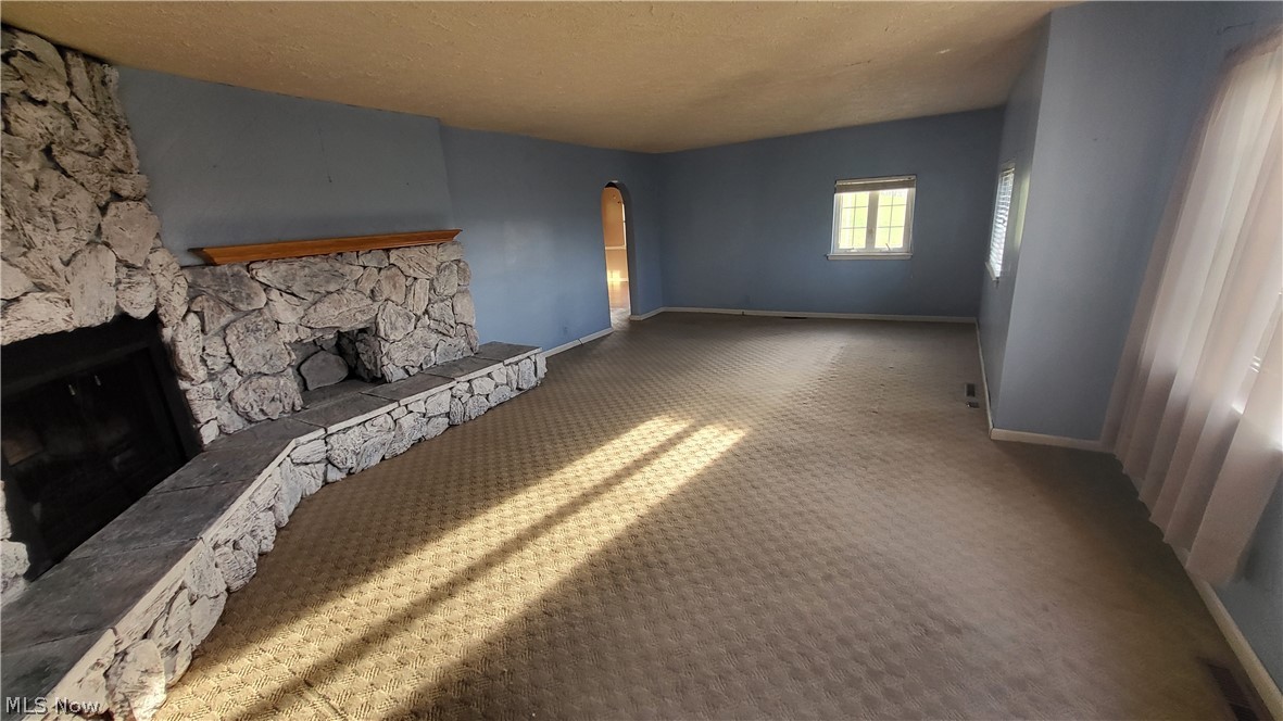 72238 Colerain Road Bridgeport, OH 43912 - Photo 15 of 30 Unfurnished bedroom with carpet floors, a textured ceiling, and a stone fireplace