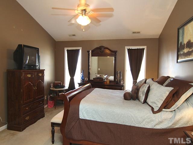282 Saddle Ridge Drive Willow Spring, NC 27592 - Photo 13 of 23 a bedroom with a bed and dresser with mirror