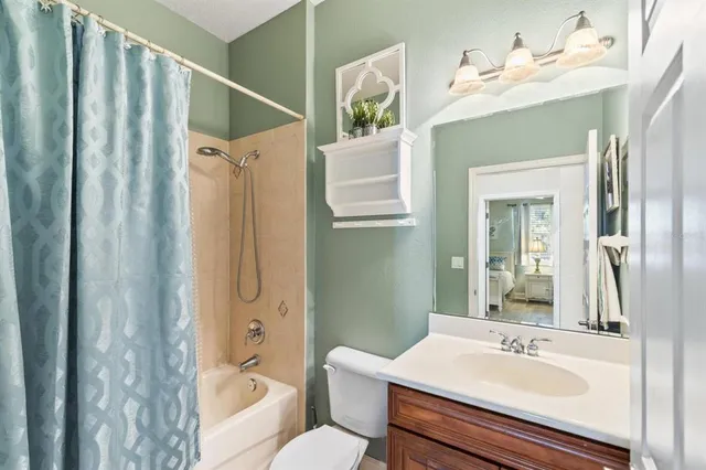 a bedroom with bed and flat tv screen on the dresser