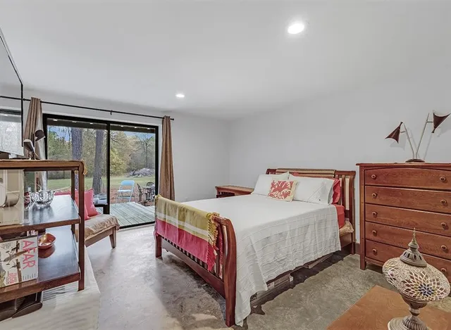 a bedroom with a bed and a dresser next to a window