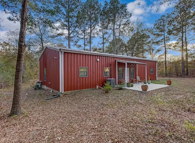 a view of a house with backyard and trees