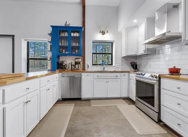 a kitchen with white cabinets stainless steel appliances and sink
