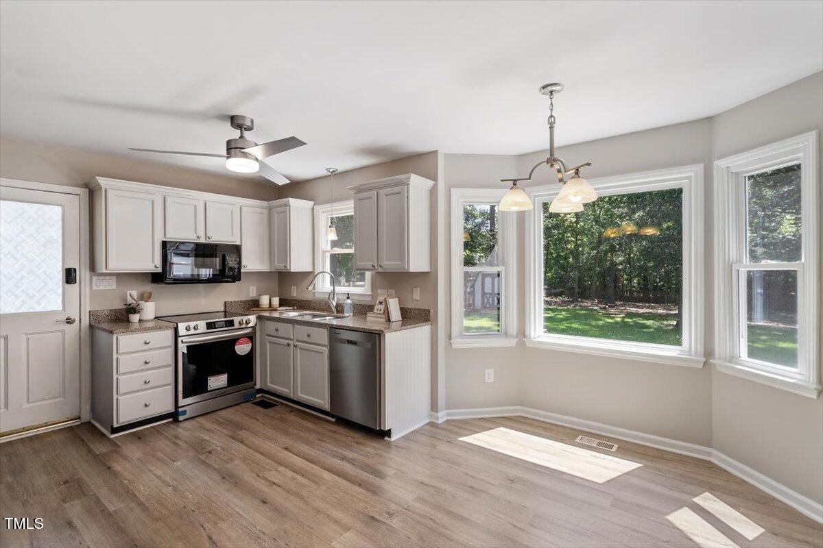 4714 Lazyriver Drive Durham, NC 27712 - Photo 15 of 37 a kitchen with stainless steel appliances granite countertop a stove cabinets and refrigerator
