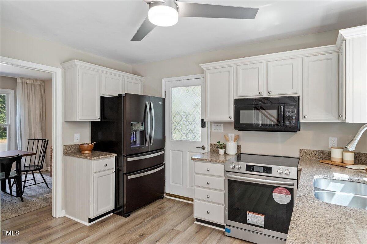 4714 Lazyriver Drive Durham, NC 27712 - Photo 17 of 37 a kitchen with cabinets stainless steel appliances and wooden floor