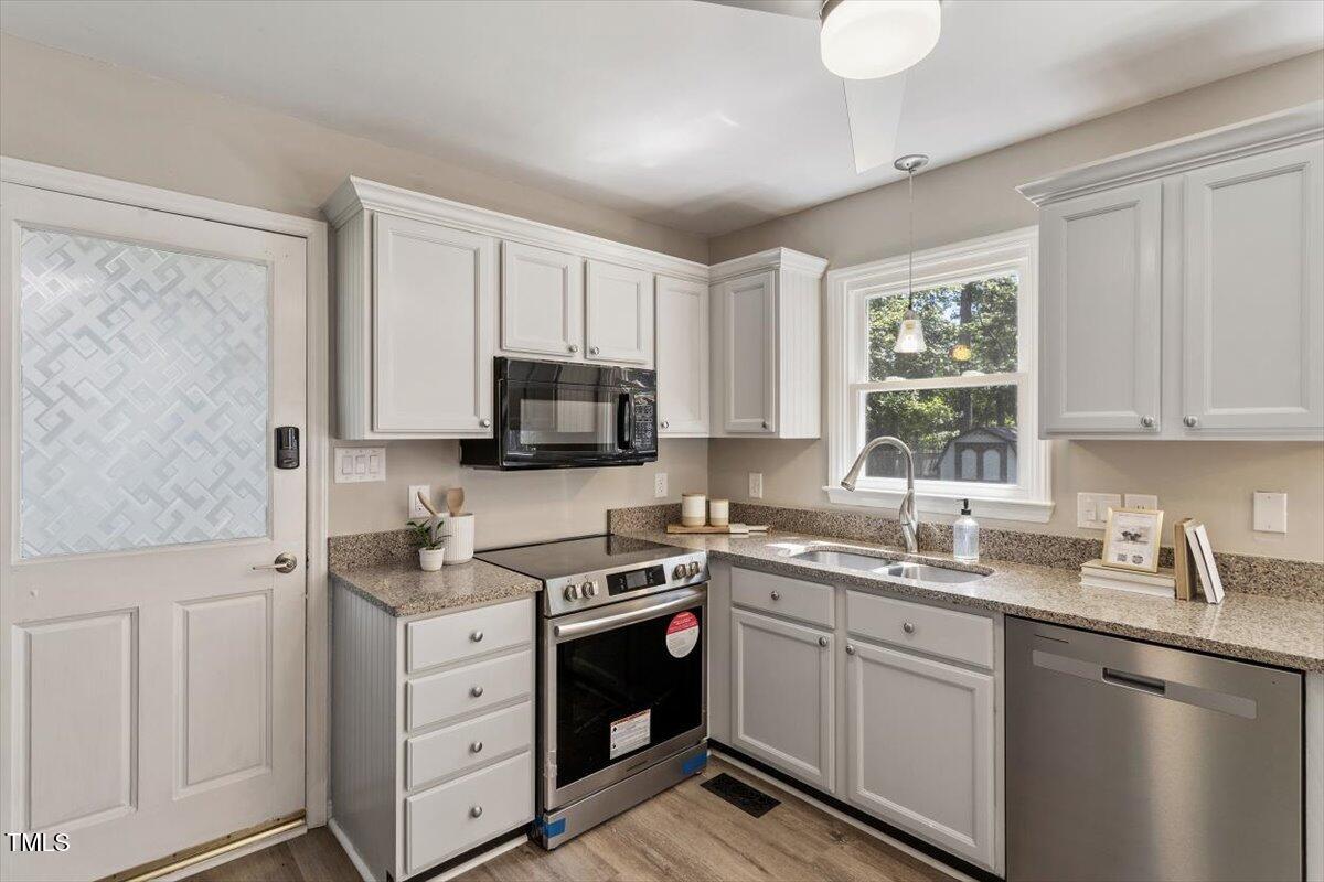 4714 Lazyriver Drive Durham, NC 27712 - Photo 21 of 37 a kitchen with white cabinets sink and window