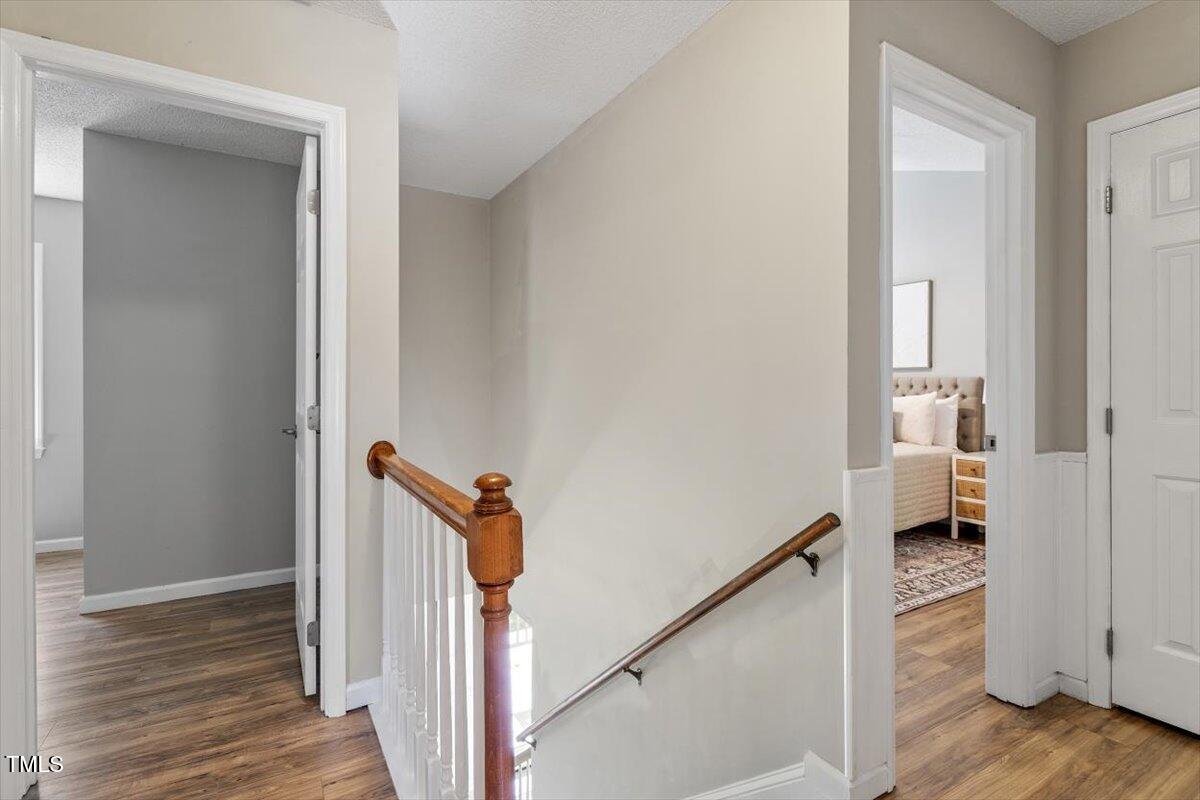 4714 Lazyriver Drive Durham, NC 27712 - Photo 22 of 37 a view of a hallway with wooden floor and staircase
