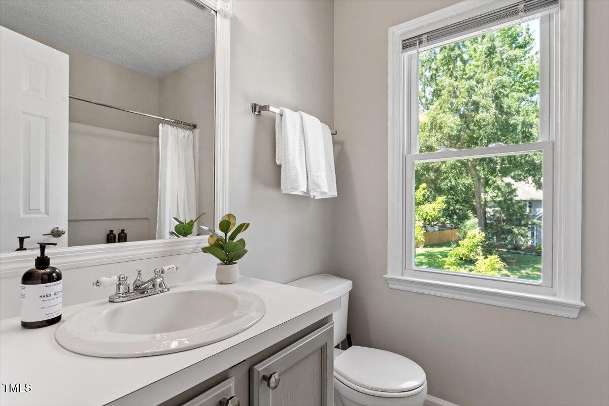 4714 Lazyriver Drive Durham, NC 27712 - Photo 28 of 37 a bathroom with a granite countertop sink toilet and mirror