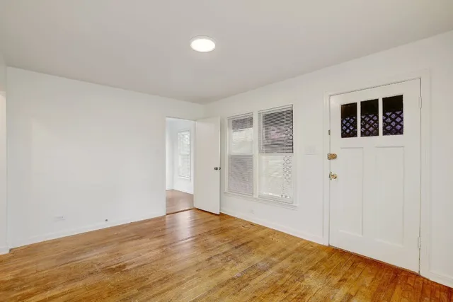 a view of an empty room with wooden floor and closet