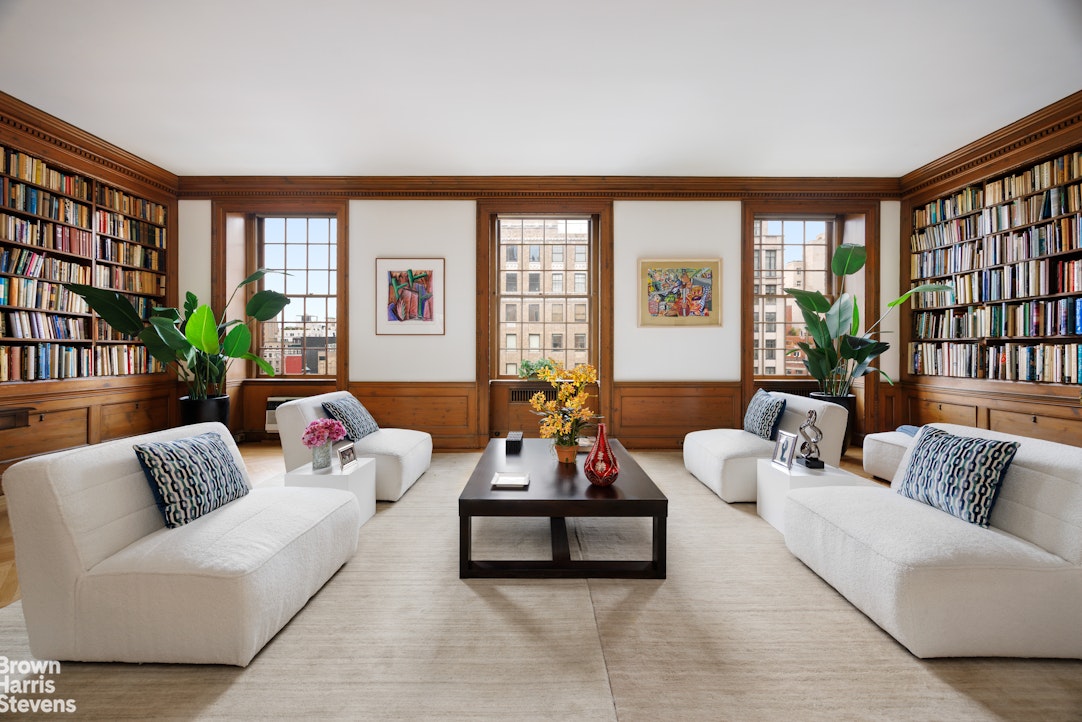 a living room with furniture and large windows with wooden floor