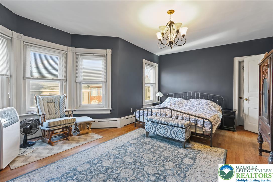 225 South Walnut Street Bath, PA 18014 - Photo 11 of 20 a spacious bedroom with a bed a chandelier and a window