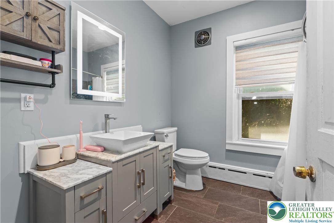 225 South Walnut Street Bath, PA 18014 - Photo 15 of 20 a bathroom with a granite countertop toilet a sink and a window