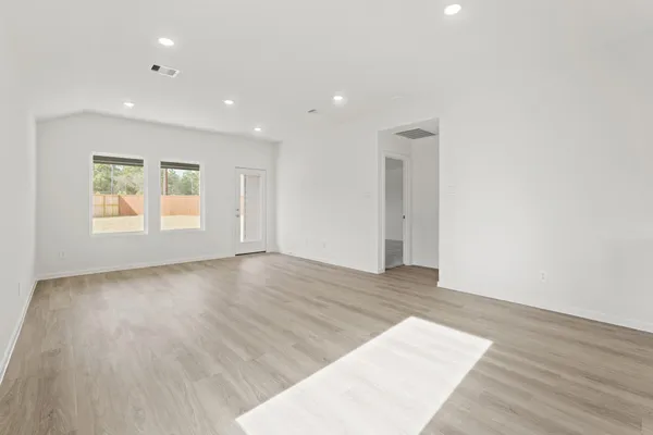 an empty room with wooden floor and a window