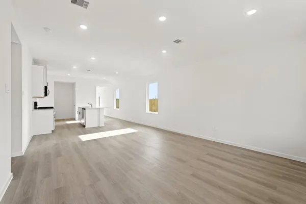 a view of empty room with wooden floor