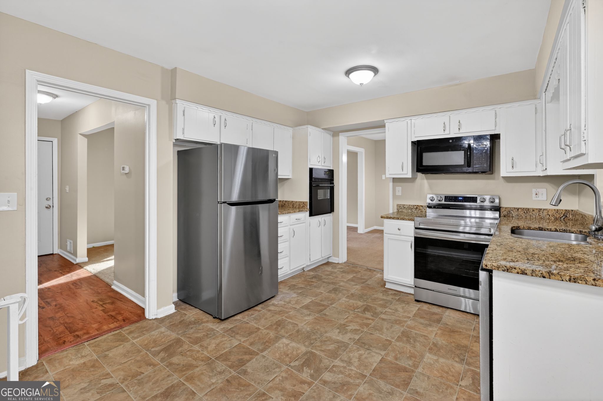2897 Leisure Woods Lane Decatur, GA 30034 - Photo 15 of 32 a kitchen with granite countertop a refrigerator and a stove top oven