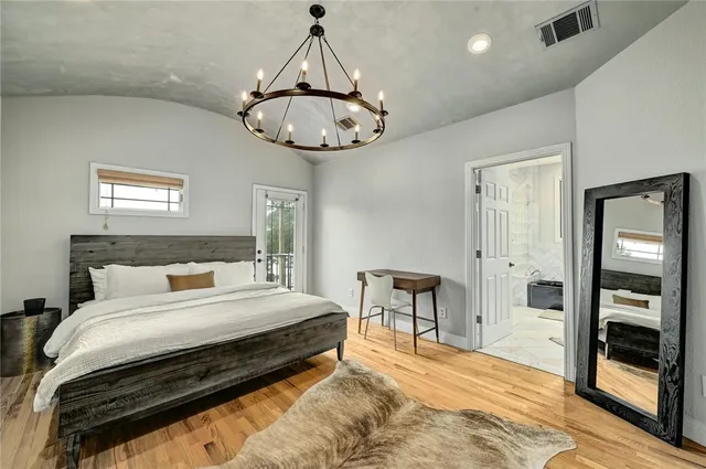a bedroom with bed and a chandelier