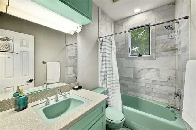 a bathroom with a sink mirror toilet and bathtub