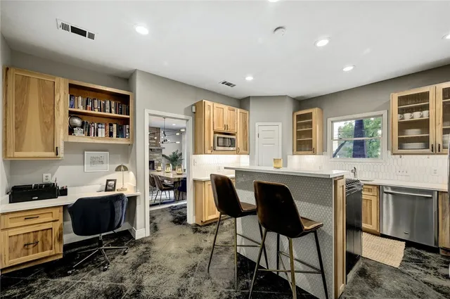 a kitchen with granite countertop a stove a sink a dining table and chairs