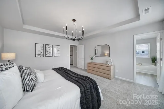 a bedroom with a large bed and a chandelier