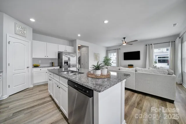 a kitchen with granite countertop a sink and cabinets