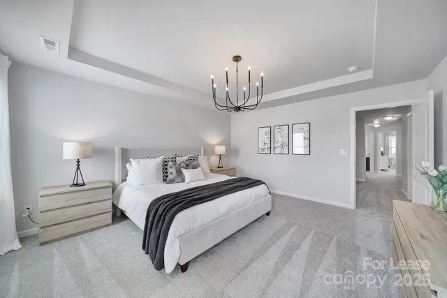 a bedroom with bed and a chandelier