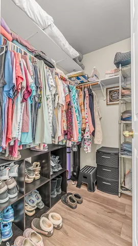 a view of walk in closet with clothes and shoes