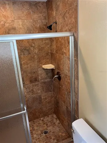 a bathroom with a shower and toilet