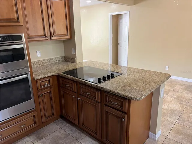 a kitchen with granite countertop a sink and cabinets