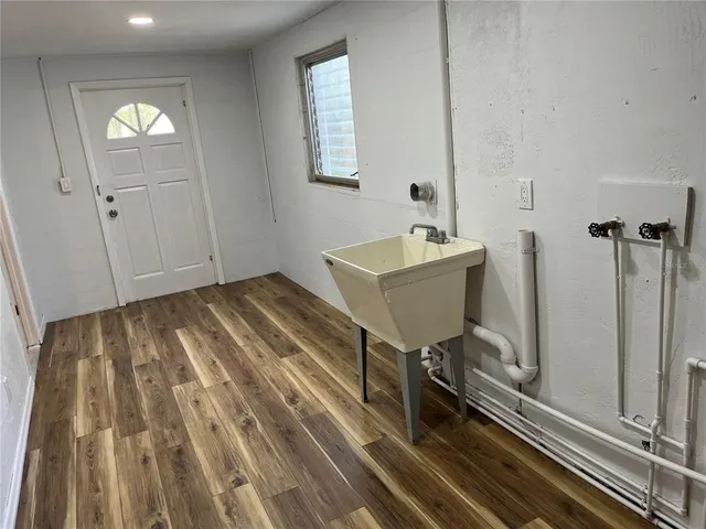 a view of a bedroom with wooden floor and windows