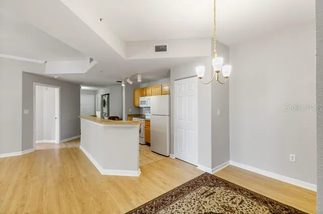 a view of kitchen with furniture a refrigerator and a window