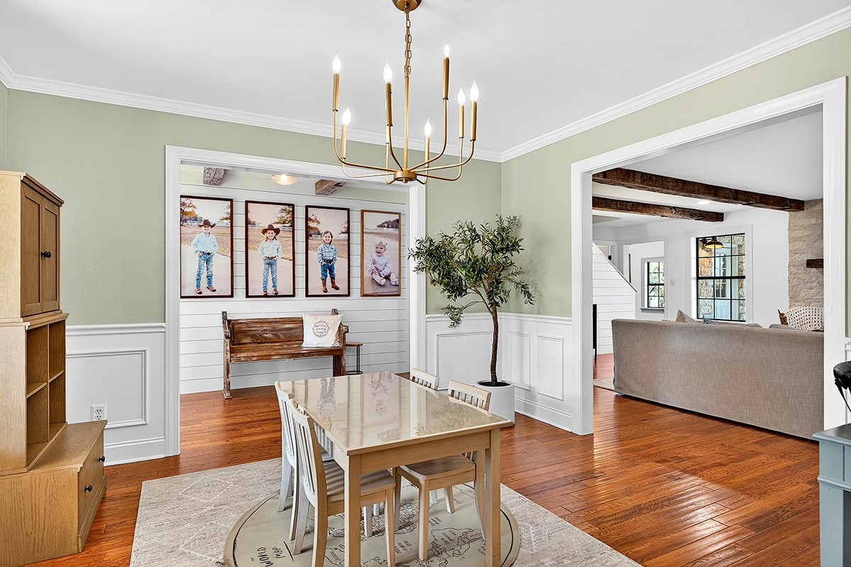 301 Medlin Creek Loop Dripping Springs, TX 78620 - Photo 13 of 40 Dining room featuring ornamental molding, a chandelier, wood-type flooring, and wainscoting