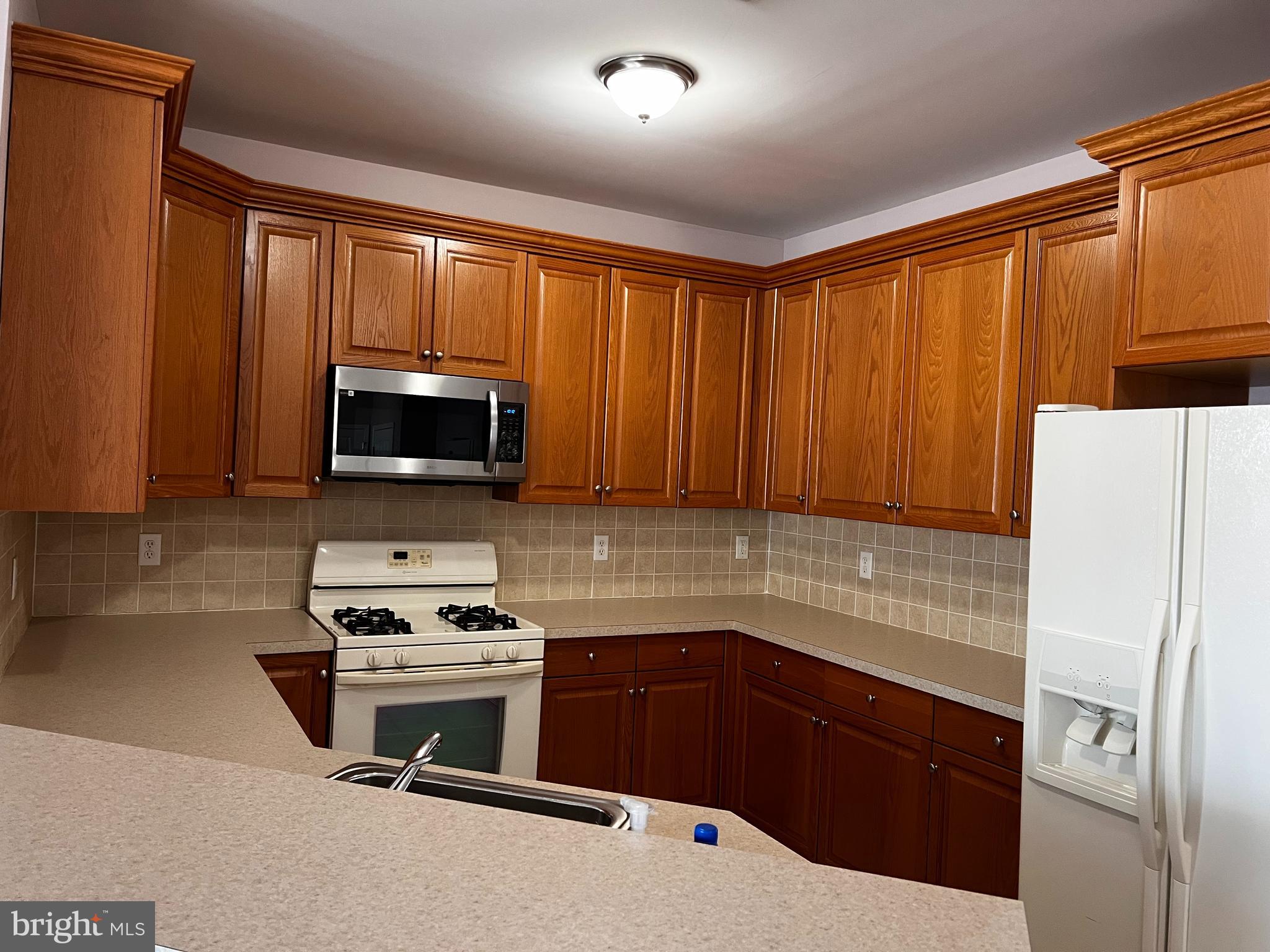 245 Masterson Court Ewing, NJ 08618 - Photo 11 of 25 a kitchen with a refrigerator a stove a sink and a microwave