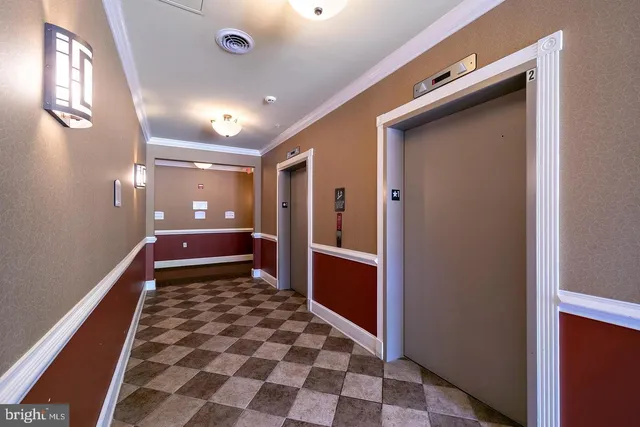 a view of a hallway with front door and wooden floor