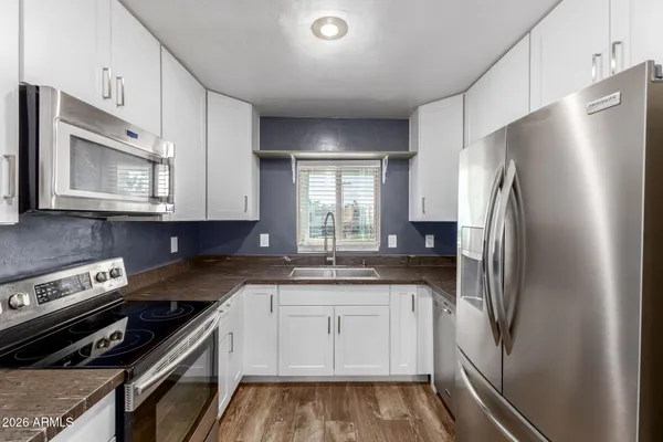 a kitchen with stainless steel appliances granite countertop a refrigerator and a stove