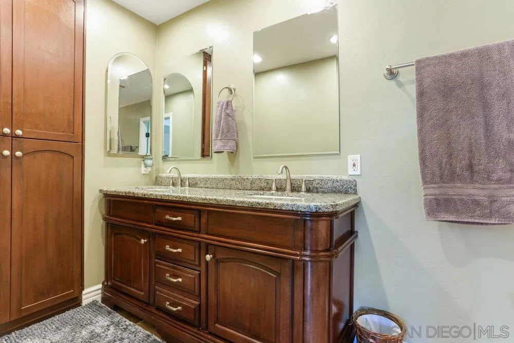 714 Steffy Road Ramona, CA 92065 - Photo 18 of 25 a bathroom with a granite countertop sink a mirror and a vanity
