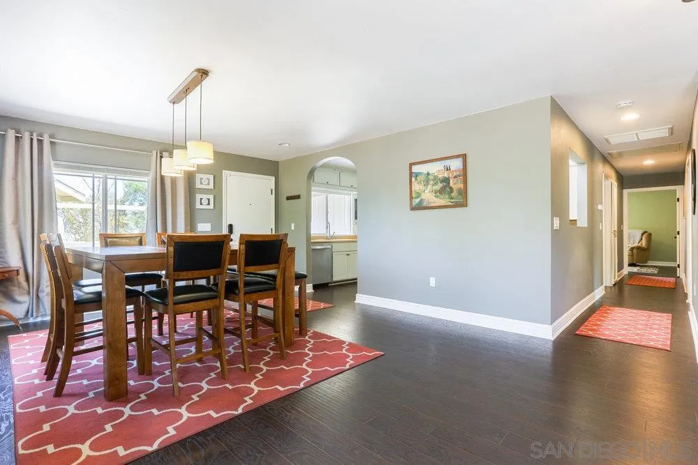 714 Steffy Road Ramona, CA 92065 - Photo 9 of 25 a dining room with wooden floor a chandelier a wooden table and chairs