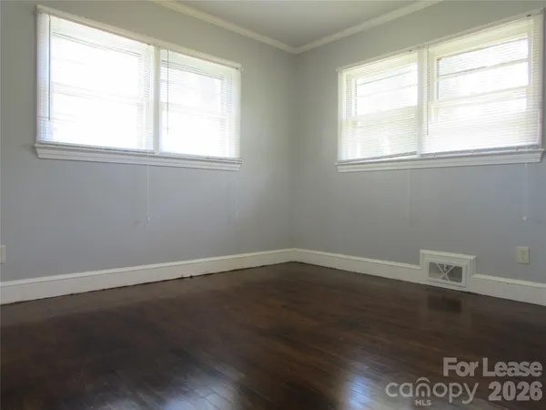 an empty room with wooden closet and a window