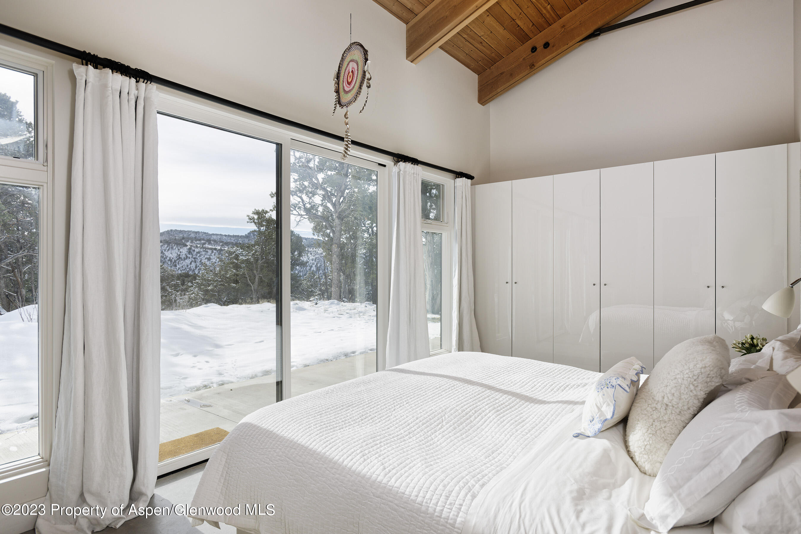 89 Sage Swale Road Carbondale, CO 81623 - Photo 11 of 23 a bedroom with a large bed and a large window