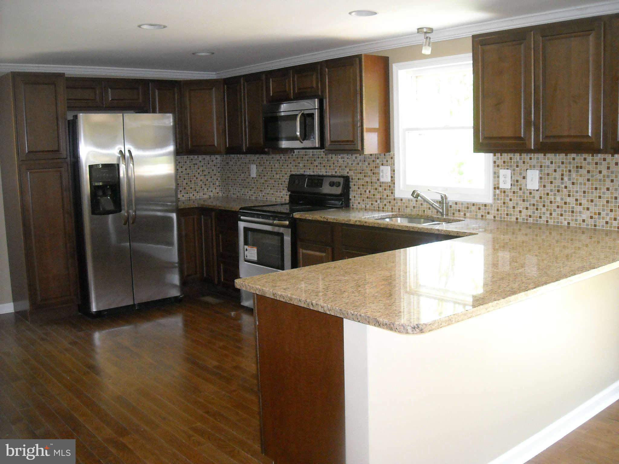 13630 Hamit Road Dowell, MD 20688 - Photo 2 of 12 a kitchen with granite countertop a stove and a refrigerator