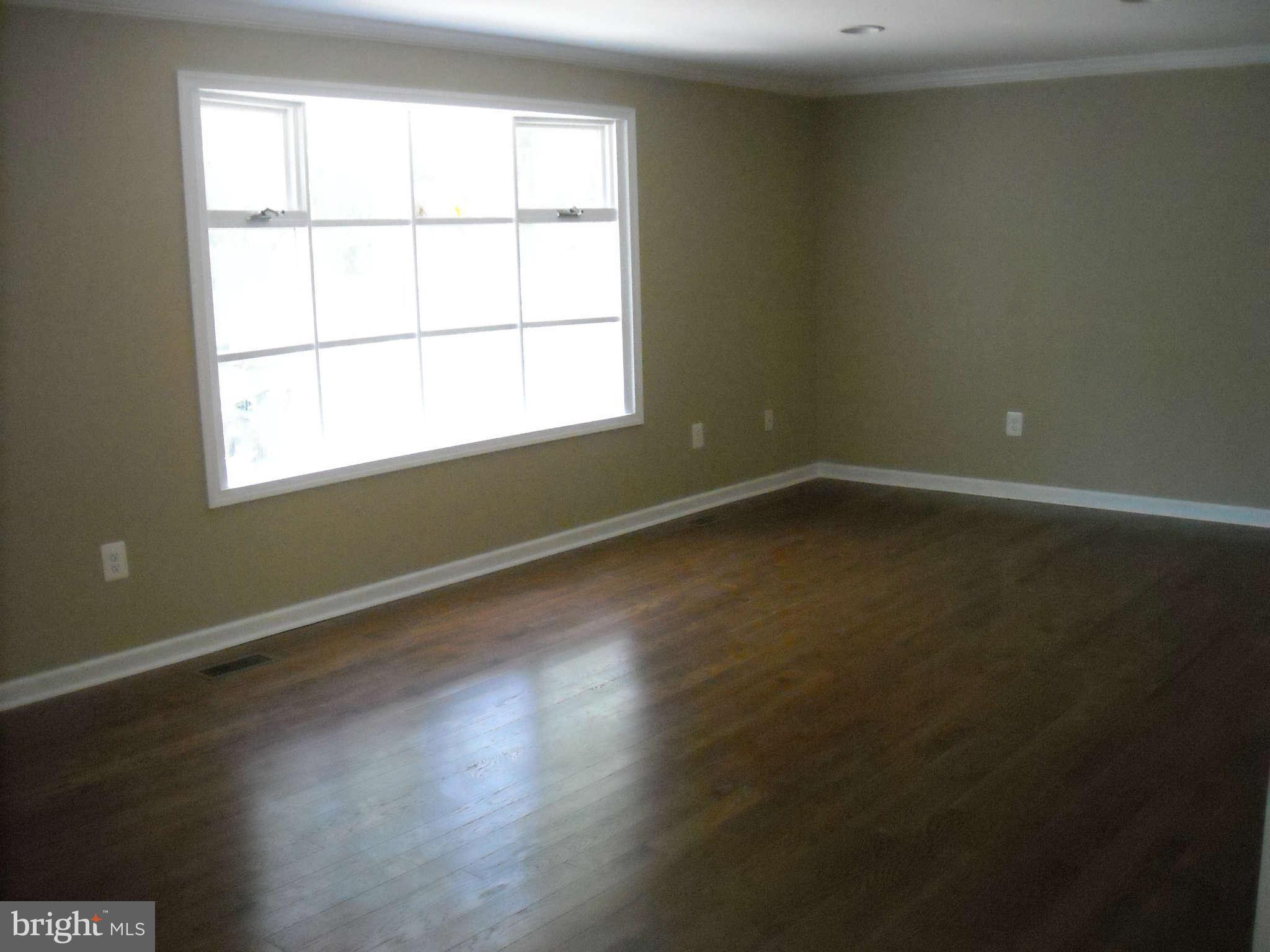 13630 Hamit Road Dowell, MD 20688 - Photo 3 of 12 an empty room with wooden floor and windows