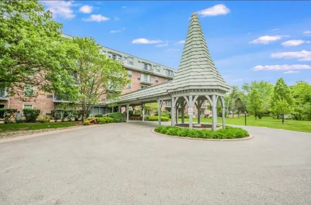 a front view of a house with a yard and potted plants