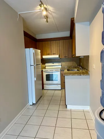 a kitchen with a stove a refrigerator and a cabinets