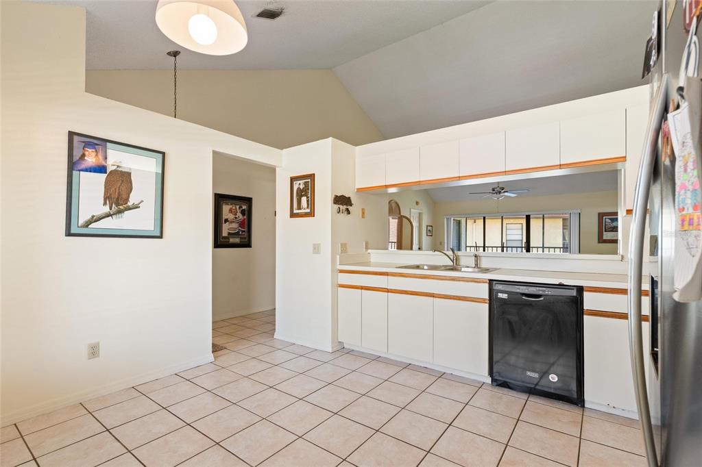 1801 East Lake Road South, Unit 4E Palm Harbor, FL 34685 - Photo 5 of 26 a kitchen with granite countertop cabinets and window