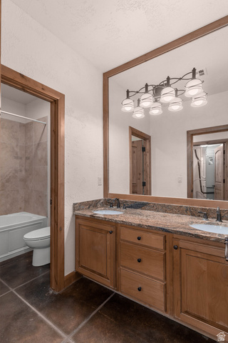 2464 East Granite Way St. George, UT 84790 - Photo 101 of 106 Bathroom featuring double vanity, finished concrete flooring, a textured wall, and shower / bathtub combination