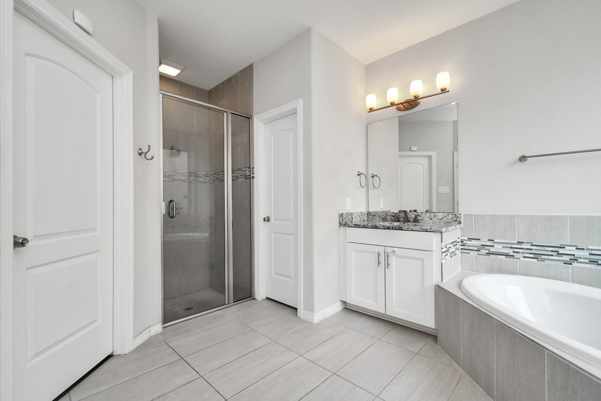 3803 May Ridge Lane Sugar Land, TX 77479 - Photo 15 of 47 a spacious bathroom with a granite countertop sink a mirror a bathtub and shower