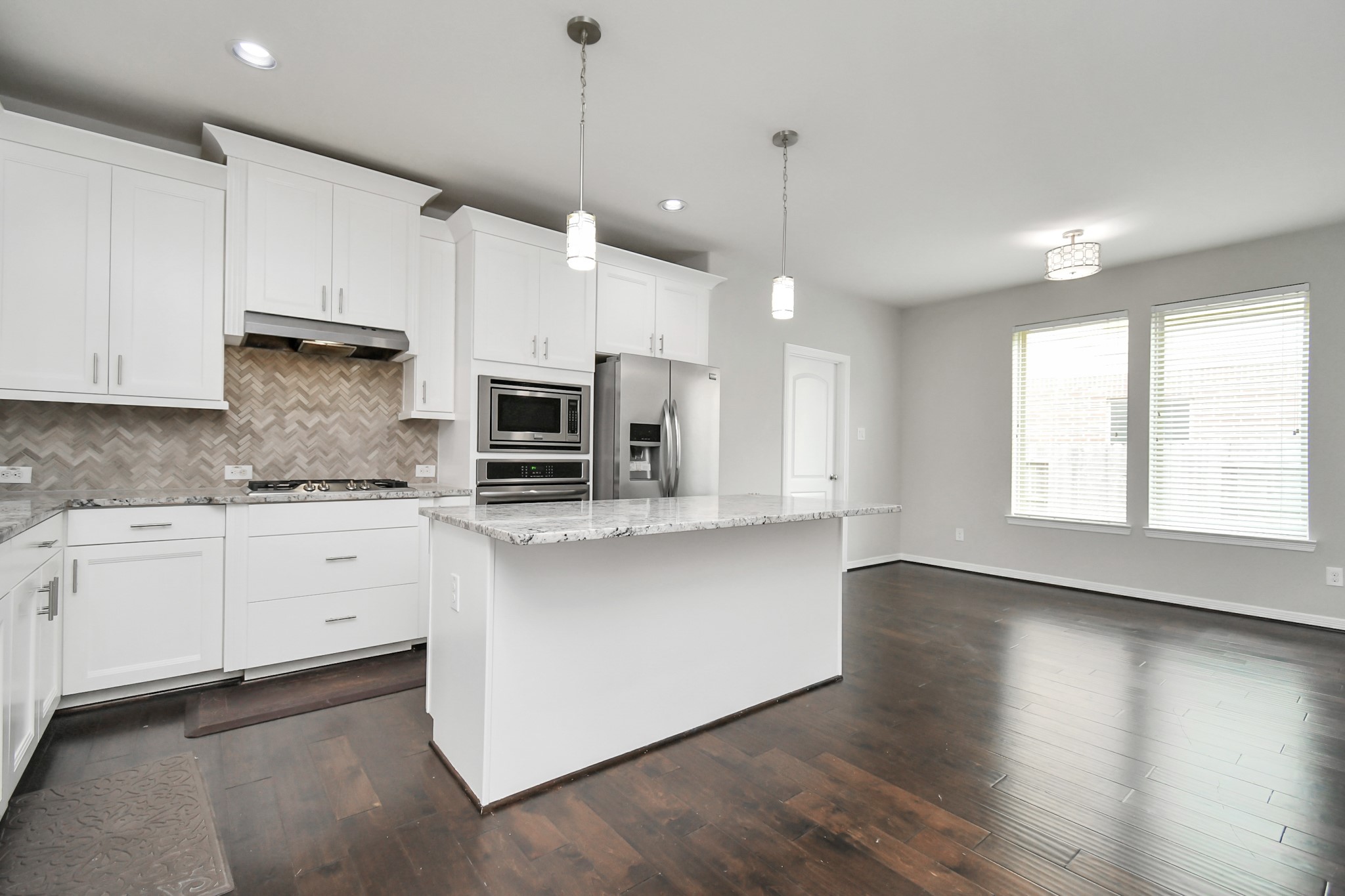 3803 May Ridge Lane Sugar Land, TX 77479 - Photo 22 of 47 a large kitchen with stainless steel appliances granite countertop a stove a sink and white cabinets with wooden floor